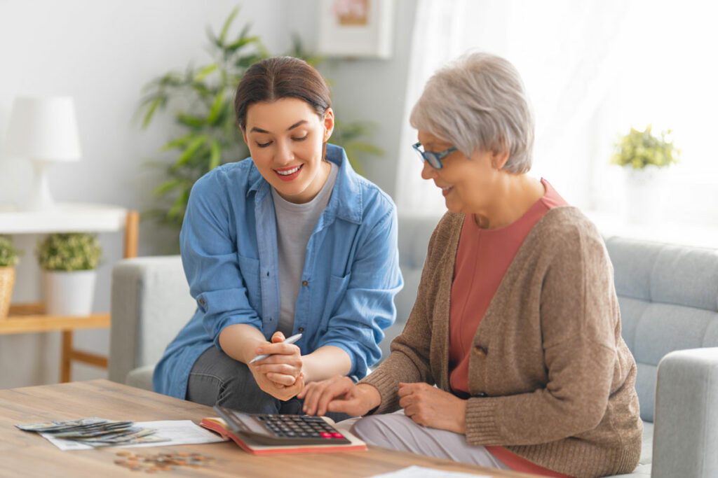 Evergreen Senior Living | Senior woman calculating financial information with associate